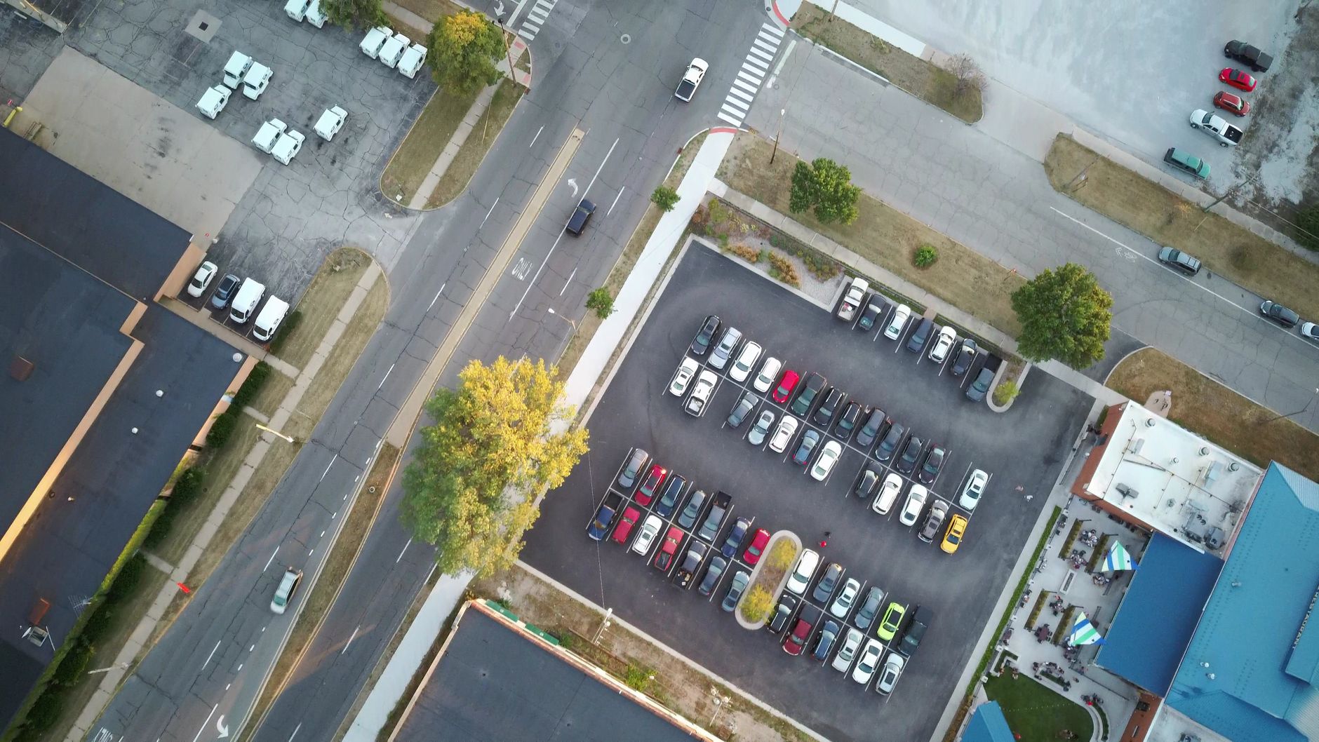 Vista aérea de um estacionamento com carros e árvores